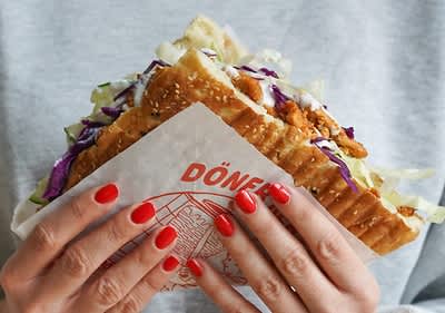 Person hält großen Döner in Händen