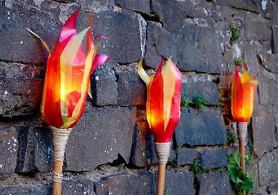 Drei brennende Fackeln an Steinmauer