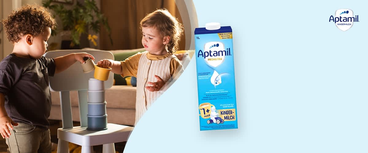 Eine blaue Verpackung für Kindermilch der Marke Aptamil mit der Aufschrift „Pronutura“ und „1+ Jahr“. Oben rechts das Aptamil-Logo.