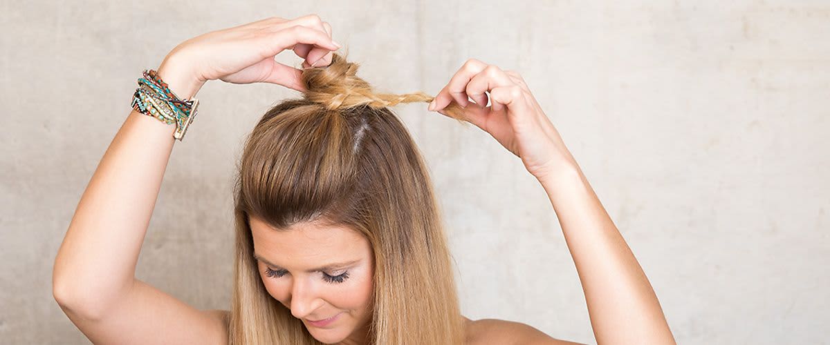 Frau flechtet Half Bun