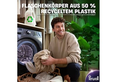 Mann wäscht Kleidung vor Waschmaschine