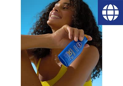 Frau hält Sonnencreme in der Hand