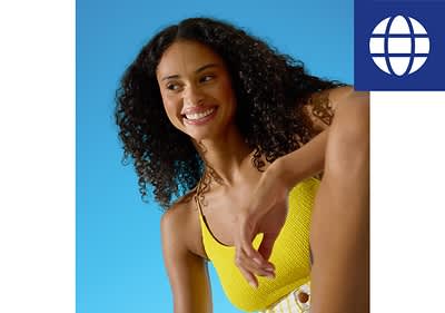 Frau in gelbem Oberteil vor blauem Hintergrund