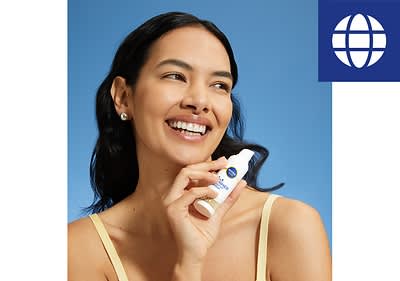 Frau hält Hautpflegeprodukt vor blauem Hintergrund