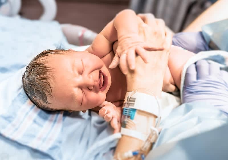 Neugeborenes Baby weint im Krankenhausbett