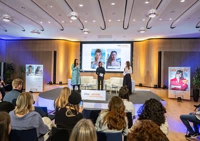 Menschen bei einer Podiumsdiskussion im Konferenzraum