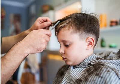 Junge bekommt Haarschnitt im Salon