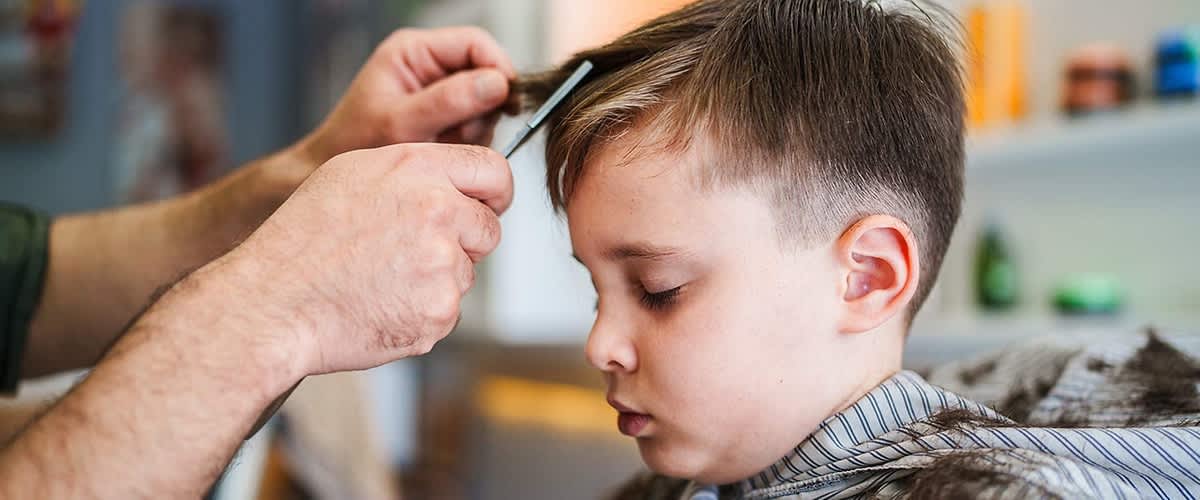 Junge bekommt Haarschnitt im Salon