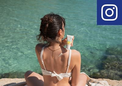 Frau am Strand mit Sonnencreme