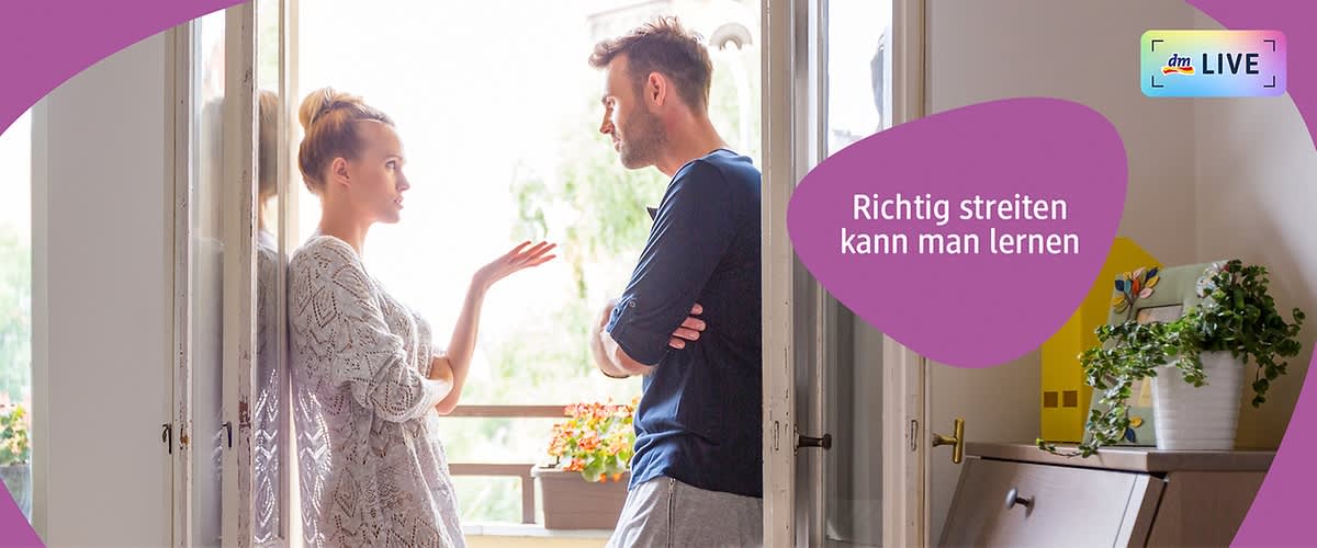 Ein Mann und eine Frau stehen sich gegenüber in einem hellen Raum mit offenem Fenster, die Frau gestikuliert mit der rechten Hand, während der Mann seine Arme verschränkt hält, beide haben unscharfe Gesichter, im Hintergrund ist ein grüner Baum sichtbar, rechts im Bild steht ein gelber Lautsprecher auf einem Tisch, auf einem lila Banner steht der Text Richtig streiten kann man lernen.