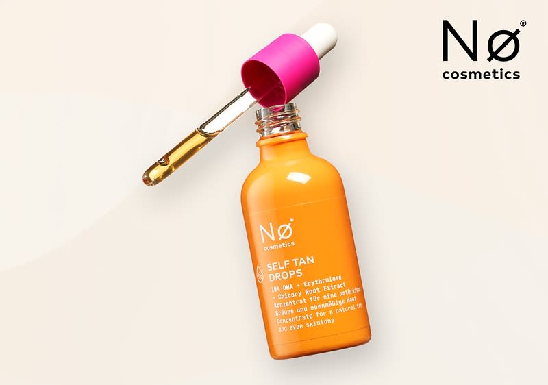Eine orangefarbene Flasche mit der Aufschrift Nø cosmetics SELF TAN DROPS und weiteren Angaben wie 10% DHA + Beet Extract und Glowy & Deep Tan Effect liegt auf einem hellen Hintergrund, daneben ein pinker Pipettendeckel mit einer transparenten Pipette, die eine gelbliche Flüssigkeit enthält, oben rechts steht Nø cosmetics in schwarzer Schrift.