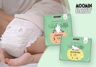 Baby trägt Moomin-Windel, zwei Packungen daneben