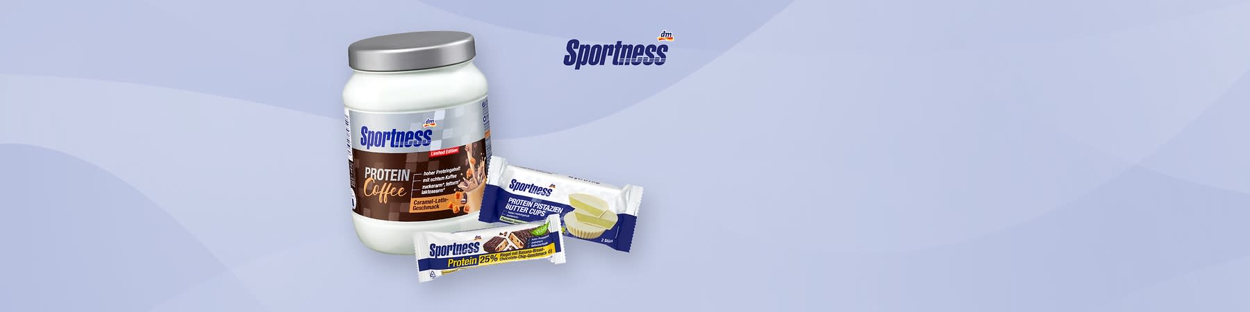 weiße Dose Sportness Protein Coffee mit silbernem Deckel und Aufschrift „Protein Coffee“ sowie zwei verpackte Sportness-Proteinsnacks nebeneinander, rechts ein weiß-blau verpackter Riegel mit Aufschrift „Protein 25%“ und oben ein weiß-blau verpackter Snack mit Aufschrift „Protein Pistazien Butter Cups“ auf hellblauem Hintergrund