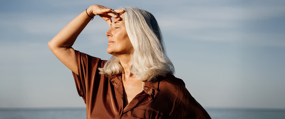 Frau schaut in die Ferne am Wasser
