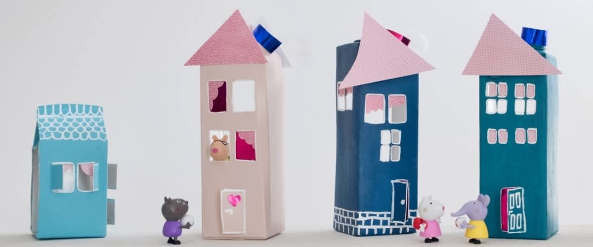 Drei bunte Häuser und zwei Spielzeugfiguren