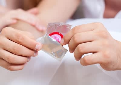 Männerhände mit einem Kondom