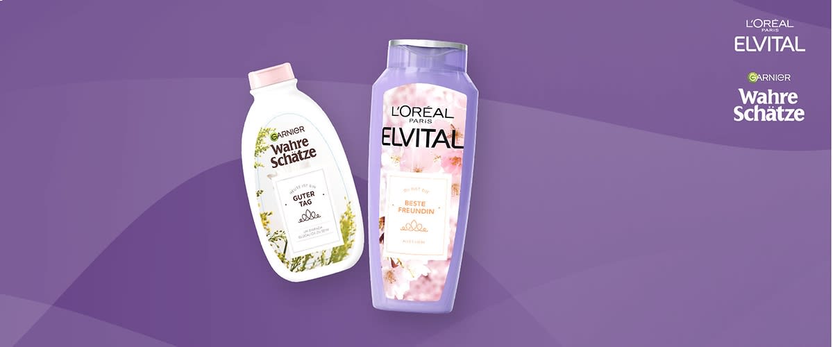 Zwei Shampooflaschen von Garnier Wahre Schätze und L'Oréal Elvital auf lila Hintergrund