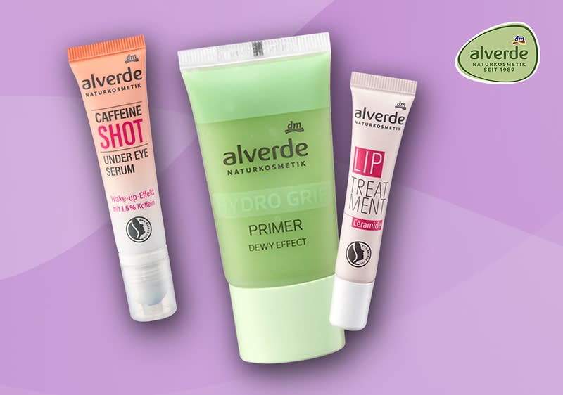Drei alverde Naturkosmetik-Produkte vor fliederfarbenem Hintergrund: links eine orange-weiße Tube mit der Aufschrift „CAFFEINE SHOT UNDER EYE SERUM“, Mitte eine grün-weiße Tube mit der Aufschrift „alverde NATURKOSMETIK HYDRO GREEN PRIMER DEWY EFFECT“, rechts eine weiße Tube mit rosa Aufschrift „alverde LIP TREATMENT“, oben rechts das runde alverde-Logo ohne weiteren Text
