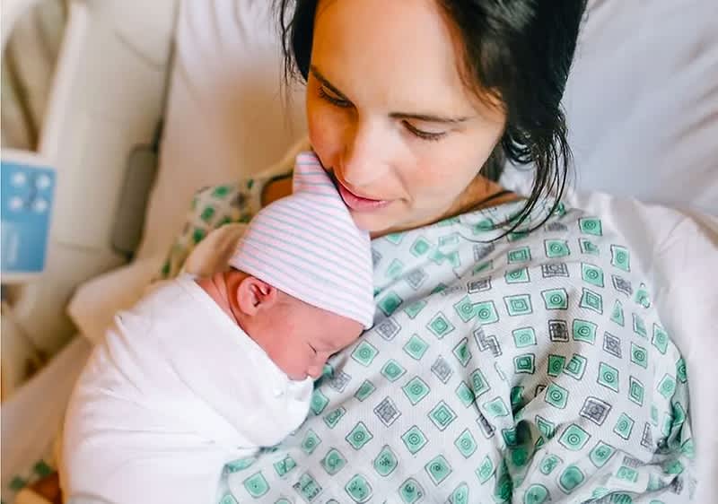Mutter hält ihr frischgeborenes Baby in den Armen