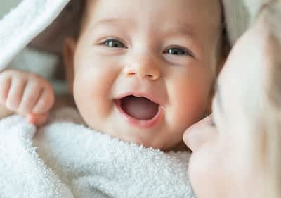 Baby in Handtuch gewickelt.