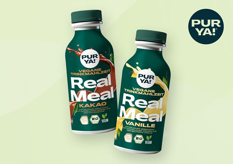 Zwei Flaschen der Marke PURYA! mit der Aufschrift Vegane Trinkmahlzeit Real Meal, eine in Kakao-Geschmack mit braunen Akzenten und die andere in Vanille-Geschmack mit gelben Akzenten, beide mit Bio- und Vegan-Siegeln, daneben ein rundes Logo mit der Aufschrift PURYA! auf einem hellgrünen Hintergrund