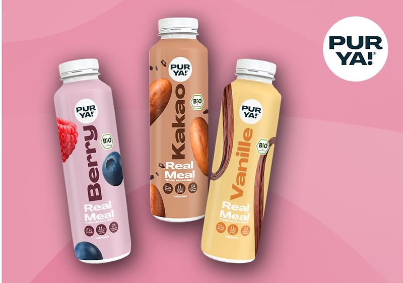 Drei Flaschen mit der Aufschrift „PUR YA! Real Meal“ in den Geschmacksrichtungen Berry, Kakao und Vanille auf rosa Hintergrund