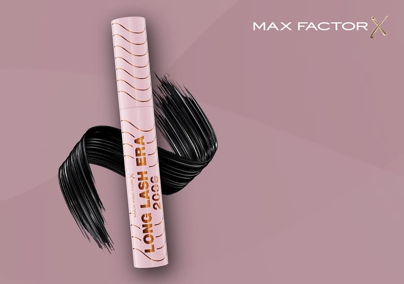 Eine rosafarbene Mascara und der Aufschrift LONG LASH ERA 2000 steht vor einem dunkelroten Hintergrund, daneben ist ein geschwungener schwarzer Mascara-Strich zu sehen, oben rechts steht MAX FACTOR in weißer Schrift, darunter ein rosa Kreis mit der Aufschrift Zuerst bei dm und dem dm-Logo.