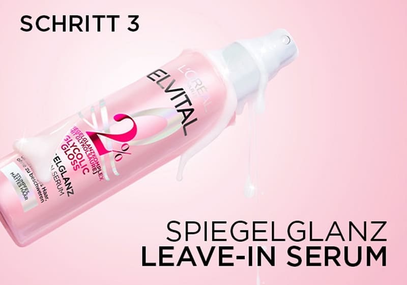 Eine Produktverpackung von L'Oréal Paris Elvital, ein Spiegelglanz Leave-In Serum in einer rosa Flasche mit einem weißen Sprühkopf, darauf steht Schritt 3, 2% Gloss, Spiegelglanz Leave-In Serum und L'Oréal Paris Elvital in schwarzer und weißer Schrift, die Flasche ist leicht mit Serum benetzt