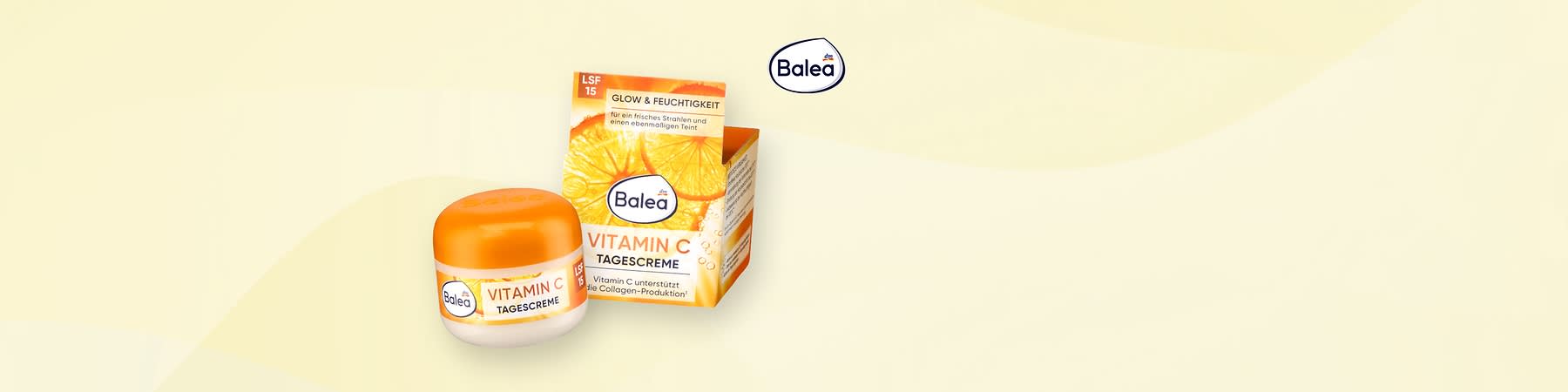 Balea Vitamin C Tagescreme im kleinen weißen Tiegel mit orangefarbenem Deckel neben der passenden orangenen Verpackungsbox mit Aufschrift „VITAMIN C TAGESCREME“, Hinweis „GLOW & FEUCHTIGKEIT“ und LSF 15