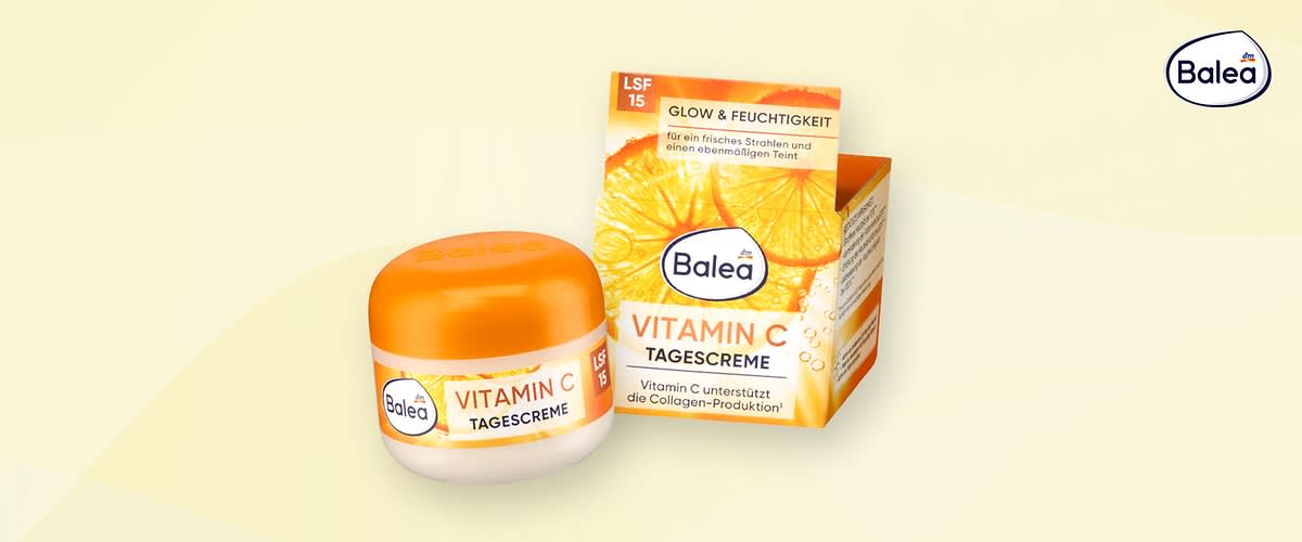 Balea Vitamin C Tagescreme im weißen Tiegel mit orangefarbenem Deckel neben der orange-gelben Produktverpackung mit der Aufschrift „VITAMIN C TAGESCREME“ und Hinweisen „LSF 15“ und „Glow & Feuchtigkeit“