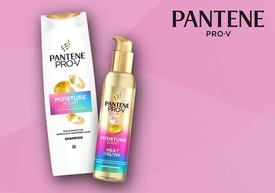 Eine weiße Shampoo-Flasche und eine goldene Leave-in-Creme-Flasche der Marke Pantene Pro-V mit der Aufschrift „Moisture Boost“ auf einem rosa Hintergrund