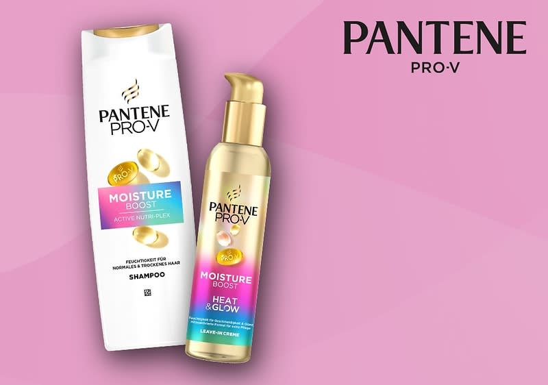 Eine weiße Shampoo-Flasche und eine goldene Leave-in-Creme-Flasche der Marke Pantene Pro-V mit der Aufschrift „Moisture Boost“ auf einem rosa Hintergrund