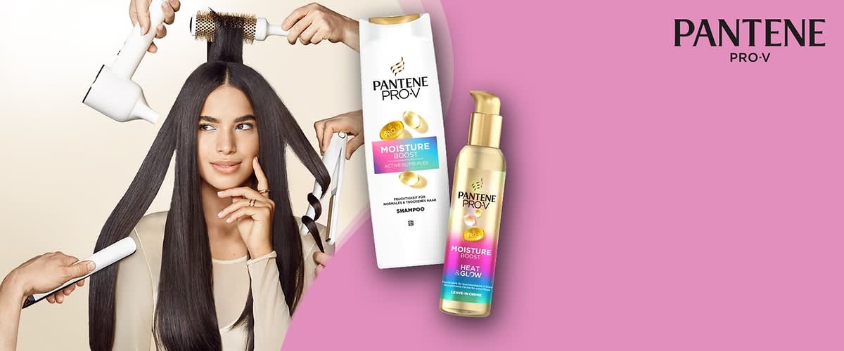 Eine weiße Shampoo-Flasche und eine goldene Leave-in-Creme-Flasche der Marke Pantene Pro-V mit der Aufschrift „Moisture Boost“ auf einem rosa Hintergrund