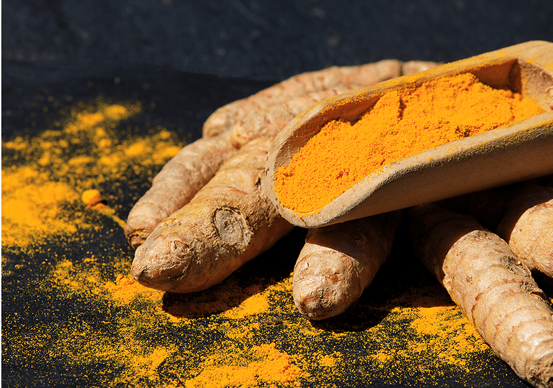 Kurkuma-Wurzeln und Kurkuma-Pulver auf dunklem Hintergrund