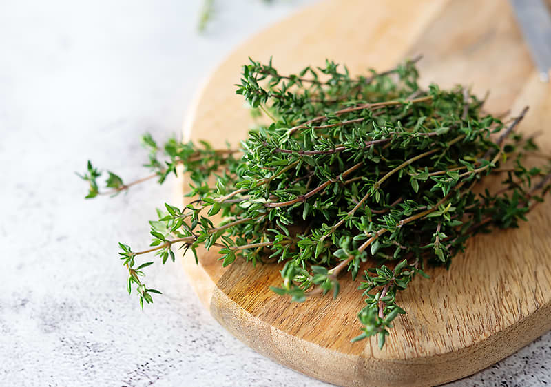 Thymianzweige auf einem Holzbrett