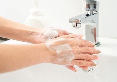 Händewaschen unter fließendem Wasser mit Seifenschaum