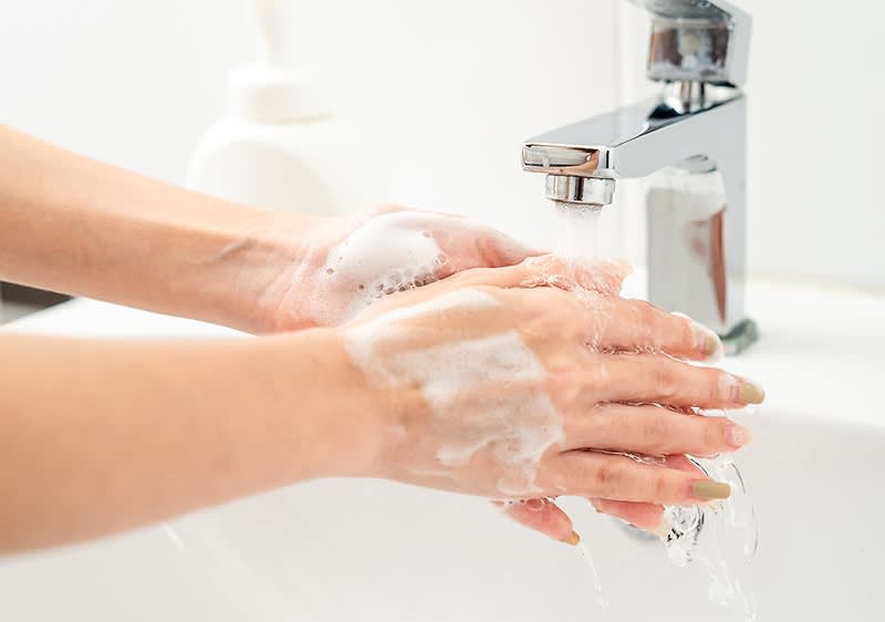 Händewaschen unter fließendem Wasser mit Seifenschaum