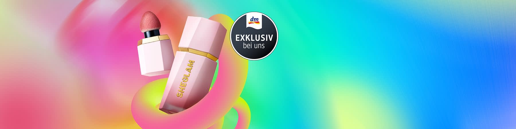 Zwei rosa SHEGLAM Kosmetikprodukte mit goldenen Akzenten vor einem bunten Hintergrund, daneben ein schwarzer Kreis mit der Aufschrift „EXKLUSIV bei uns“ und dem dm-Logo