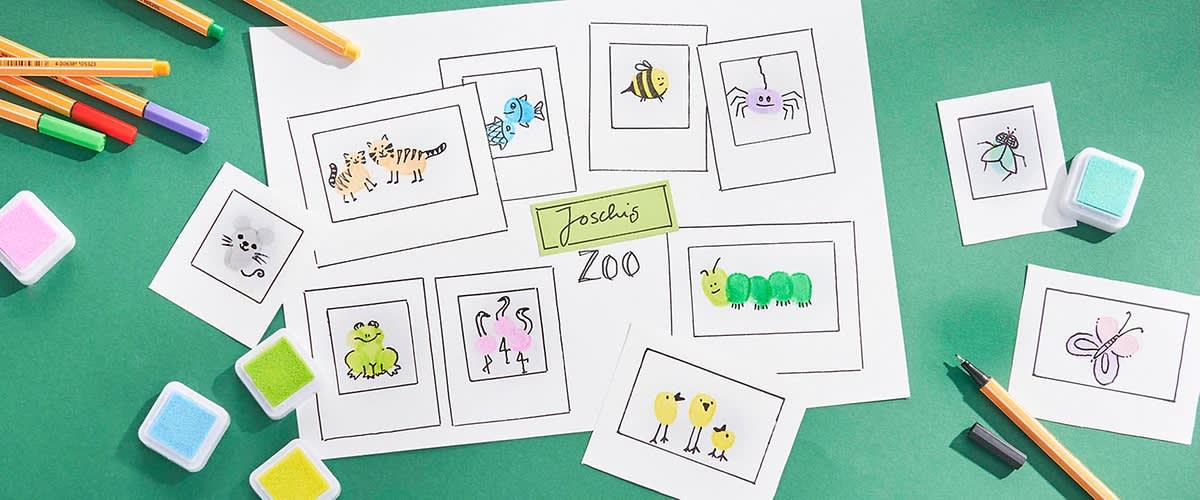 Eine Illustration zeigt verschiedene gezeichnete Tiere auf weißen Karten, darunter ein Tiger, ein Frosch, eine Raupe, ein Bienenpaar, ein Spinnenpaar, ein Schmetterling und ein Vogelpaar, umgeben von bunten Stiften und Stempeln auf einem grünen Hintergrund