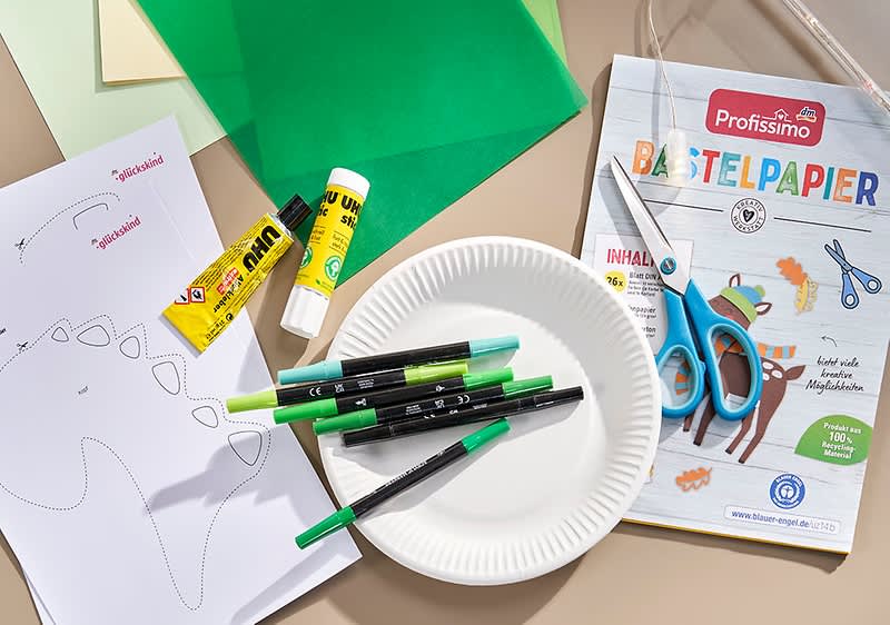 Stifte, Kleber, Pappteller, Bastelpapier und Schere für Deine Dino-Laterne