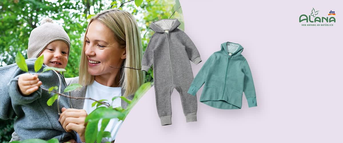 Mutter hält lächelnd Kleinkind in grauem Strampelanzug im Freien; daneben Produktabbildungen: grüner Zip-Hoodie und grauer gefütterter Einteiler mit Reißverschluss, rechts oben Logo „Alana von Anfang an natürlich“ und kleines dm-Logo