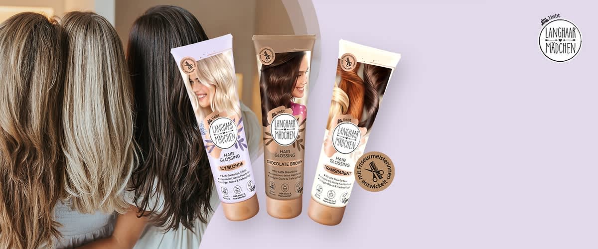 Drei Frauen mit langen Haaren stehen nebeneinander, die Köpfe leicht geneigt. Vor ihnen sind drei Haarpflegeprodukte von Langhaarmädchen zu sehen. Die Verpackungen sind in den Farben Lila, Braun und Weiß gehalten, mit der Aufschrift „Hair Glossing“. Oben rechts das Logo von Langhaarmädchen mit dem Text „das liebt Langhaarmädchen“