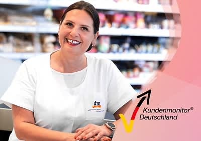 Eine Person in weißer Arbeitskleidung mit dm-Logo sitzt vor einem Regal, daneben das Logo von Kundenmonitor Deutschland