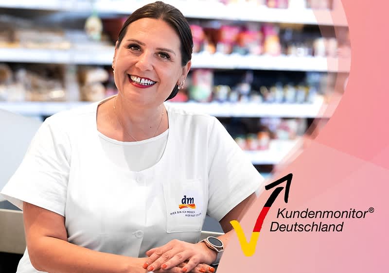 Eine Person in weißer Arbeitskleidung mit dm-Logo sitzt vor einem Regal, daneben das Logo von Kundenmonitor Deutschland