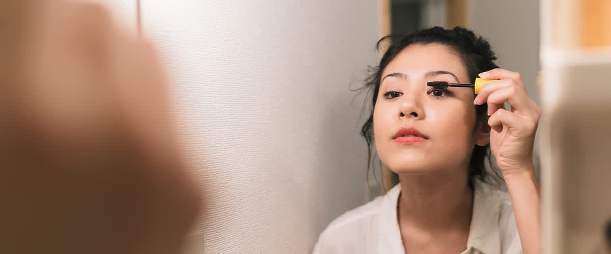 Frau nutzt Make-Up-Produkt um Augen größer zu schminken