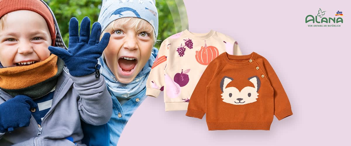 Zwei Kinderpullover, einer in Creme mit bunten Früchten und einem Kürbis, der andere in Orange mit einem Fuchs-Motiv, daneben das Logo von Alana