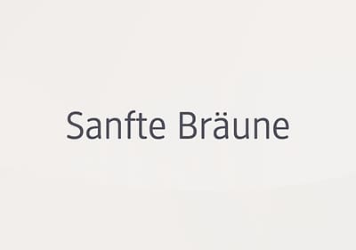 Der Text „Sanfte Bräune“ in schwarzer Schrift auf einem hellen Hintergrund