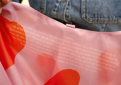 Catalin hält eine rosa Einkaufstasche mit roten Herzen und der Aufschrift „Lass Platz für Wunder“