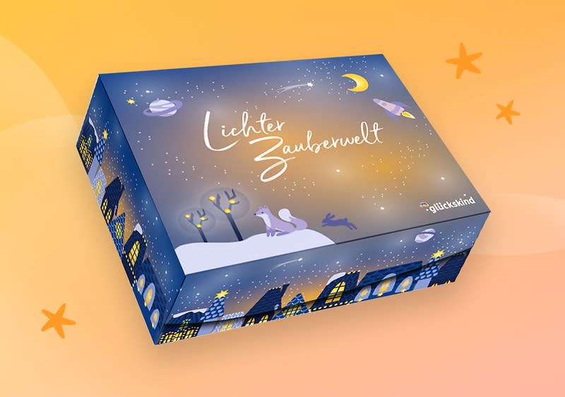 Eine blaue Verpackung mit der Aufschrift „Lichter Zauberwelt“ zeigt eine winterliche Stadtlandschaft mit beleuchteten Häusern und Bäumen, oben rechts das Logo von „glückskind“