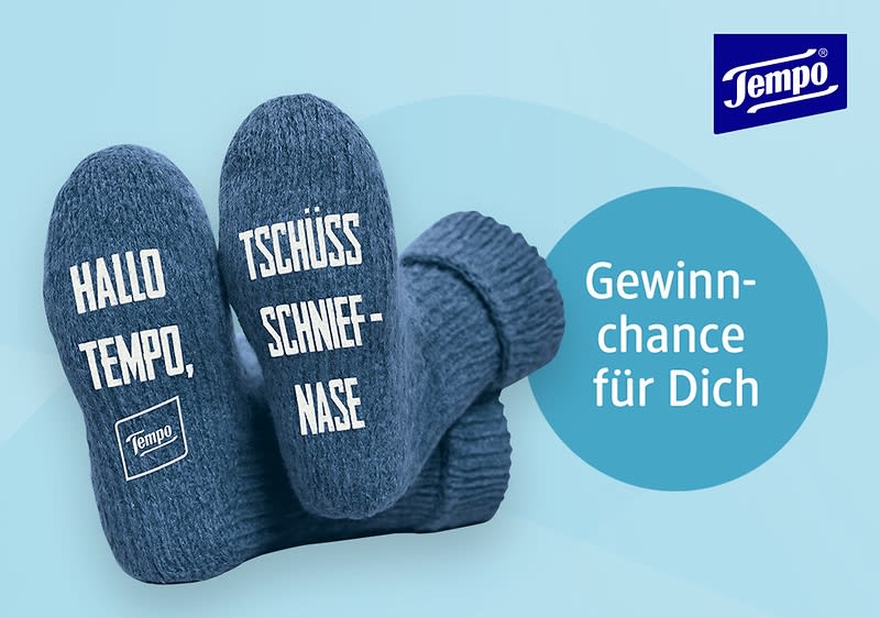 Zwei blaue Socken mit den Aufschriften „Hallo Tempo“ und „Tschüss Schniefnase“, daneben ein blauer Kreis mit dem Text „Gewinnchance für Dich“ und das Logo von Tempo